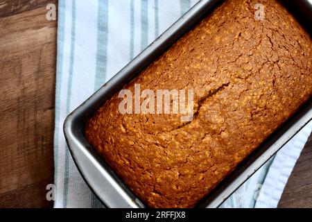 Frisch gebackener Laib mit gewürztem Kürbisbrot auf rustikalem Hintergrund Stockfoto