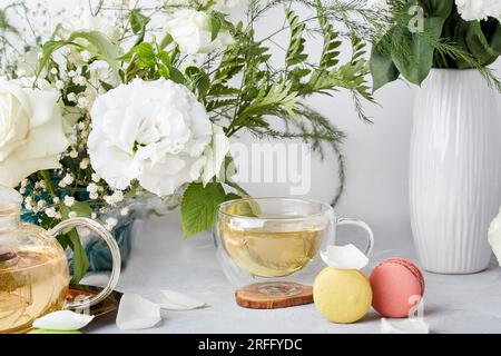 Kräutertee, Makronen, Blumen, Lebensstil. Ganz einfach: Weibliche Ruhe für dich Stockfoto