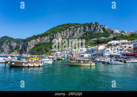 Boote liegen in Marina Grande mit den majestätischen Kalksteinklippen dahinter auf der Insel Capri im Golf von Neapel in der Region Kampanien in Italien vor Stockfoto