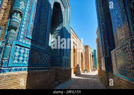 Schöner historischer Friedhof von Shahi Zinda Eingangstor mit fein dekorierten blauen und türkisfarbenen Steinmosaiken Mausoleen in Samarkand, Usbekistan. Stockfoto