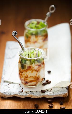 Ricotta-Creme mit frischer Kiwi und Kaffee in einem Glas Stockfoto