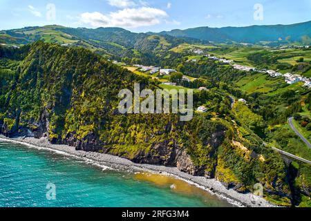 Luftaufnahme, Drohnenansicht, malerische Natur der Azoren. Grüne Hügel und bewölkter Himmel, Blick auf den Atlantischen Ozean am sonnigen Sommertag. Sao Miguel, P. Stockfoto