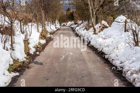 Green Lane in Baildon, eine Landstraße nach starkem Schnee. Die Spur ist frei, Schneeverwehungen bleiben auf beiden Seiten. Stockfoto