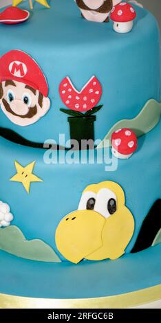 Super Mario Bros Geburtstagsparty Kuchen - Pastelblauer Geburtstagskuchen. Festlicher Kuchen mit blauem Marzipan Stockfoto