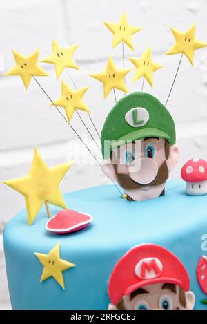 Super Mario Bros Geburtstagsparty Kuchen - Pastelblauer Geburtstagskuchen. Festlicher Kuchen mit blauem Marzipan Stockfoto