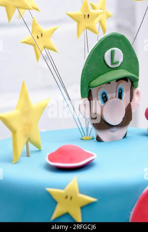 Super Mario Bros Geburtstagsparty Kuchen - Pastelblauer Geburtstagskuchen. Festlicher Kuchen mit blauem Marzipan Stockfoto