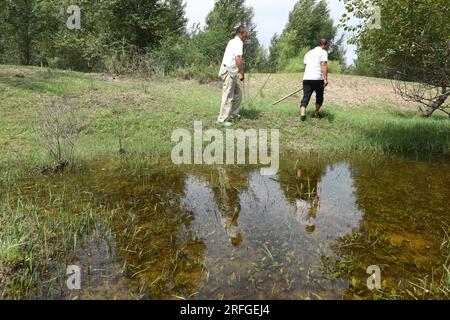 (230803) -- TONGLIAO, 3. August 2023 (Xinhua) -- Bai Shun (L) und sein Sohn patrouillieren einen Wald in Bulteger Gacha, Horqin Left Wing Rear Banner von Tongliao City, Nordchina innere Mongolei Autonome Region, 2. August 2023. Im Zentrum des Horqin Sandy Land befindet sich Bulteger Gacha, ein kleines Dorf im Horqin Left Wing Rear Banner von Tongliao City, das früher unter Wüstenbildung litt. Seit 2002 hat Bai Shun, ein lokaler mongolischer Bauer, seine Familie in diesem Dorf Wurzeln geschlagen und sich der Kontrolle der Wüstenbildung verschrieben. Die Überlebensrate der gepflanzten Bäume war zu Beginn aufgrund von niedrig Stockfoto