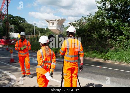 Harefield, Großbritannien. 3. August 2023. Der Bau des HS2 High Speed Rail Colne Valley Viaduct durch Align JV wird fortgesetzt. Die Moorhall Road (abgebildet) in Harefield, im Londoner Stadtteil Hillingdon, ist derzeit für den Verkehr gesperrt, da auf der anderen Straßenseite temporäre Stützstrukturen unter Viaduksegmenten errichtet werden, die von einem Kran zusammengebaut werden. Das Colne Valley Viaduct überquert die Moorhall Road zwischen Korda Lake und Savay Lake, südlich des Grand Union Canal. Die Infrastruktur- und Projektbehörde hat das HS2-Milliarden-Pfund-Projekt zwischen London an verlegt Stockfoto