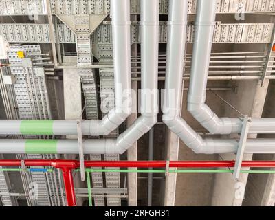 Die große komplexe Rohrleitung verschiedener Systeme hängt im Bau an der Decke des städtischen Bahnhofs, Vorderansicht für den Copy Spac Stockfoto