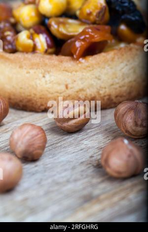 Weizentörtchen mit Nüssen und getrockneten Früchten in Sahne-Karamell, Weizentörtchen mit süßer Füllung, knusprige Törtchen mit Haselnüssen, Erdnüssen und anderen in Stockfoto