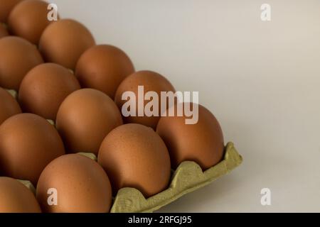 Karton mit rohen braunen Eiern mit Leerstelle rechts neben dem Foto Stockfoto