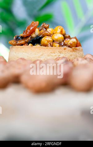 Kleine runde Törtchen mit verschiedenen Füllungen, knusprige Törtchen mit Haselnüssen, Erdnüssen und anderen Zutaten, Teig Törtelnüsse und getrocknete Obstbucht Stockfoto