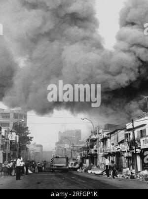 SAIGON, VIETNAM - ca. 31. Januar 1968 - Schwarzer Rauch bedeckt Bereiche der Hauptstadt, und Feuerwehrautos stürzen sich zu den während der Anschläge entstandenen Feuern Stockfoto