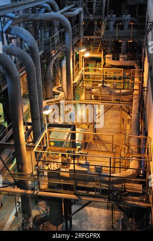 Altes und rostiges Wärmekraftwerk, gruseliges Industriegebäude, dunkler Ort, viele Rohre und Metallkonstruktionen, Industrieinnere Stockfoto