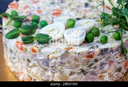 Ein traditioneller russischer olivier-Salat aus gekochter Wurst, eingelegten grünen Erbsen, Eiern, Mayonnaise und eingelegten Gurken Stockfoto