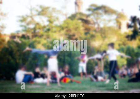 Junge Menschen liegen auf dem Rasen, schickes. Starke Blur, anonyme Menschen auf den Straßen Europas Stockfoto