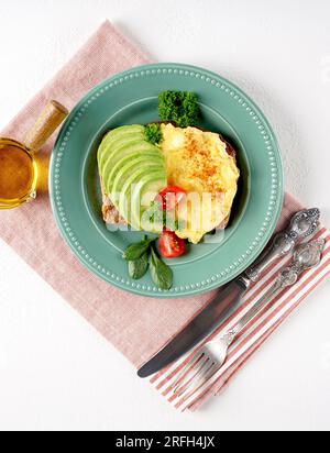 Omelette mit Tomaten und Avocado auf Brot, Draufsicht. Stockfoto
