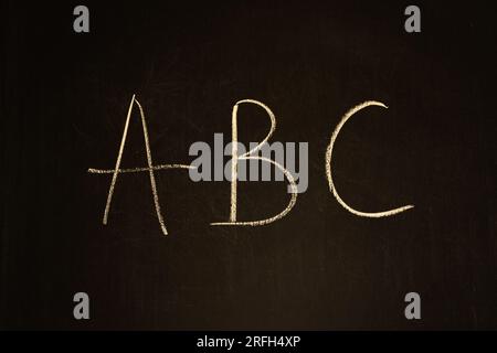 Kreidezeichnung an einer Tafel. Buchstaben ABC auf Holzbrett. Schultafel. Alphabet-Konzept. Handgeschriebener Text. Vorschulerziehung. Stockfoto