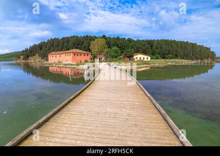 Fußgängerbrücke auf der Insel Zveraq in der Lagune von Narta, Albanien. Insel umgeben von der atemberaubenden Kulisse aus ruhigem Wasser und üppigem Grün. Stockfoto