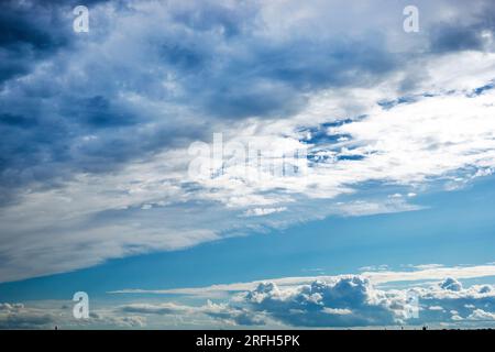 Blauer Himmel mit stürmischen und welligen weißen Wolken vor Regen. Wetterwechsel Stockfoto