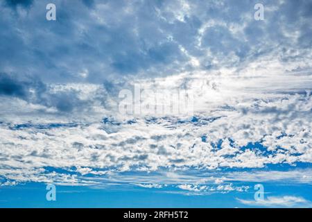Blauer Himmel mit stürmischen und welligen weißen Wolken vor Regen. Wetterwechsel Stockfoto