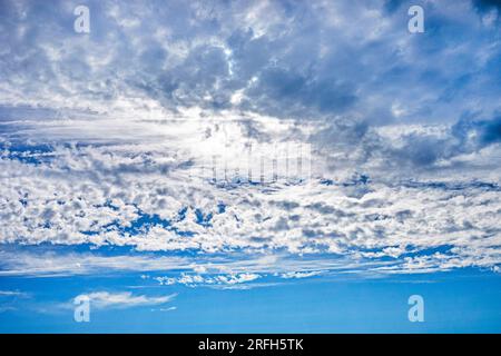Blauer Himmel mit stürmischen und welligen weißen Wolken vor Regen. Wetterwechsel Stockfoto