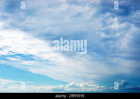 Wunderschöner blauer Himmel mit stürmischen und welligen weißen Wolken vor Regen. Wetterwechsel Stockfoto