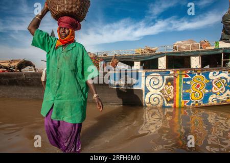 Fischer und Arbeiter, die im Hafen von Mopti Fische entladen. Mali, Westafrika Stockfoto