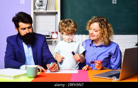 Erster Schultag. Ein Junge aus der Grundschule. Privatunterricht. Lehrerinnen und Lehrer, die Kindern aus der Grundschule helfen. Süßes Kind, das lernt Stockfoto