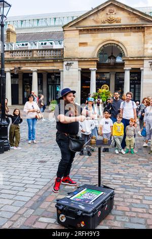 Der australische Magier Jason Maher tritt im Covent Garden im Londoner West End WC2 auf und unterhält eine Menge Stockfoto