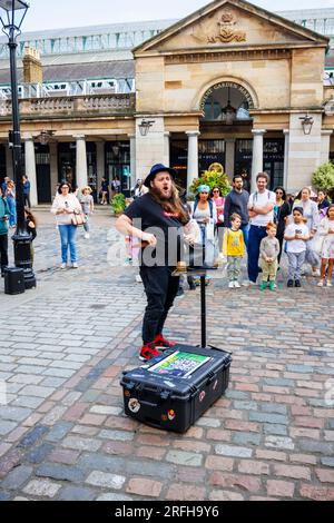 Der australische Straßenmagier Jason Maher tritt im Covent Garden im Londoner West End WC2 auf und unterhält eine Menge Stockfoto