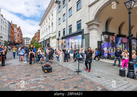 Der australische Straßenmagier Jason Maher tritt im Covent Garden im Londoner West End WC2 auf und unterhält eine Menge Stockfoto