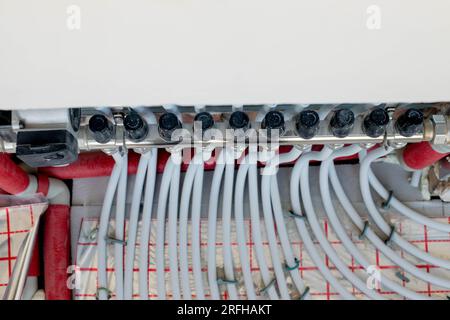 Montieren Sie die Systemverteilerbaugruppe der Fußbodenheizung zu Hause. Stockfoto