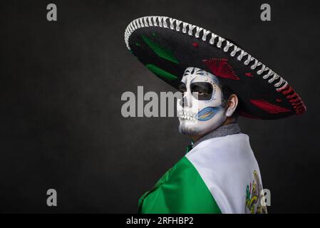 Porträt von catrin mit Charro-Hut und mexikanischer Flagge. Der Tag der Toten. Stockfoto