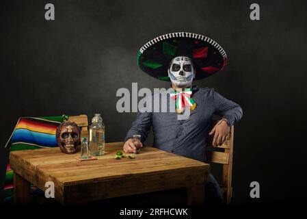 Catrin trägt einen Mariachi-Hut und bringt in einer Bar einen Toast aus. Der Tag der Totenfeier. Stockfoto
