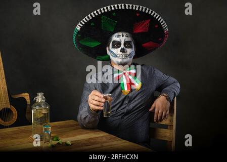 Catrin trägt einen Mariachi-Hut und bringt in einer Bar einen Toast aus. Der Tag der Totenfeier. Stockfoto