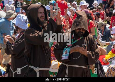 Lissabon, Portugal. 03. Aug. 2023. Ein Mönch und sein Begleiter werden dabei gesehen, wie sie während der Feier der WYD 2023 Mass mit ihrem Mobiltelefon ein Foto machen. Der Weltjugendtag ist eine religiöse Aktivität, die mit der Anwesenheit junger Menschen aus der ganzen Welt bei einem Treffen mit dem Papst einhergeht. Sie findet alle zwei, drei oder vier Jahre mit internationalem Charakter in einer Stadt statt, die vom Obersten Pontifex ausgewählt wurde. Kredit: SOPA Images Limited/Alamy Live News Stockfoto