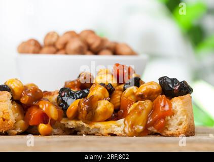 Weizentörtchen mit Nüssen und getrockneten Früchten in Sahne-Karamell, Weizentörtchen mit süßer Füllung, knusprige Törtchen mit Haselnüssen, Erdnüssen und anderen in Stockfoto