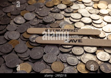 Ein Nahfoto indischer Rupien-Münzen auf einem Tisch mit dem Wort „Ruhestand“ auf einem Stock Stockfoto