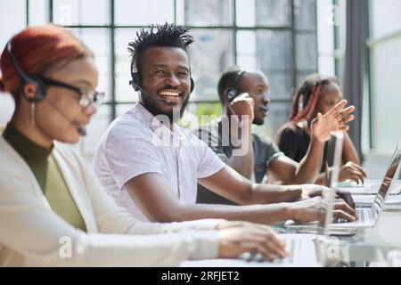Callcenter-Mitarbeiter, die im Büro gut gelaunt arbeiten. Stockfoto