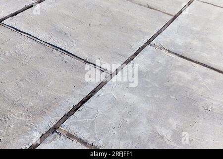 Teil einer Betonstraße aus Betonplatten, Betonplatten der Straße, die durch Holzbretter getrennt sind Stockfoto