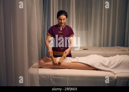 Erfahrener Masseur gibt dem Patienten eine Unterschenkelmassage Stockfoto