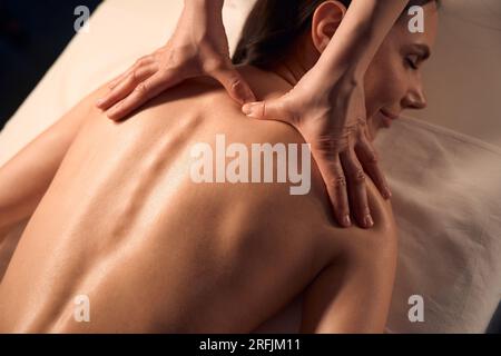 Erfahrener Spa-Therapeut gibt dem Kunden eine Triggerpunktmassage Stockfoto