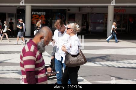 Stockholm, Schweden - 23. Mai 2023: Die Menschen in der Mitte schauen auf ihre Mobiltelefone Stockfoto