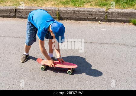 Ein Junge fährt an einem sonnigen Tag auf einer Asphaltstraße Skateboard. Extremsport. Stockfoto