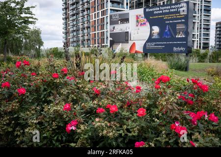 Landschaftlich gestaltete Sträucher und Blumen vor einem Schild, das am Flussufer von Berkeley am 1. August 2023 in London, England, für zukünftige Häuser am Flussufer wirbt. Stockfoto