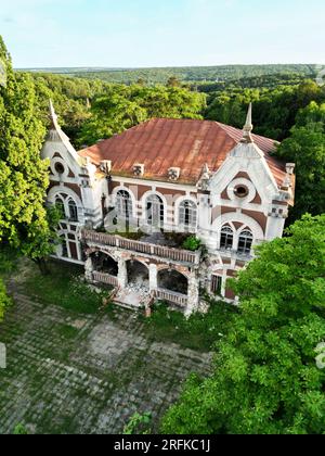 Drohnenblick auf das Pommer Mansion in Taul, Moldawien. Altes verlassenes Gebäude mit Grünflächen umgeben Stockfoto