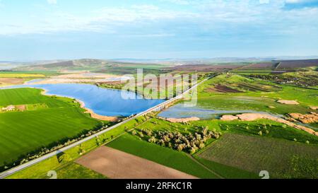 Luftdrohnenansicht der Natur in Moldawien. Ein Fluss mit einer Autobahn, Felder und Hügel Stockfoto