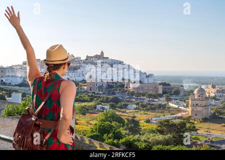 Junger, eleganter Tourist mit Hut und Blick auf Ostuni, die weiße Stadt im Süden italiens Stockfoto