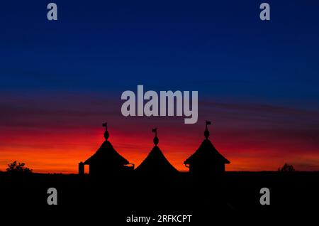 Silhouette eines atemberaubenden Schlosses über einem roten und blauen Himmel. Stockfoto